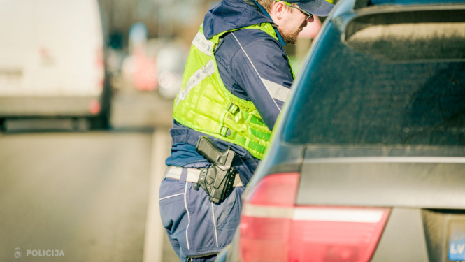 Valsts policijas amatpersona pie automašīnas