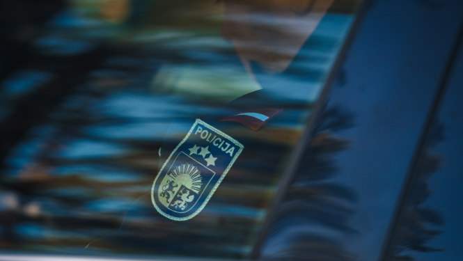 policijas darbinieks sēž mašīnā