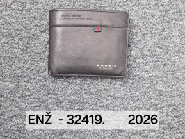 Melns salokāms maks ar uzrakstu “BOWEIS LEATHER” un nelielu sarkani zaļu auduma akcentu priekšpusē, novietots uz pelēka paklāja.