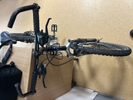 Melns TECHNOBIKE 851 kalnu velosipēds ar zilām detaļām, amortizāciju un ragiem uz stūres, fotografēts no sāna un priekšpuses.