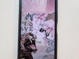 Melns telefons REDMI melnā vāciņā.