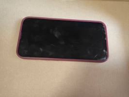 Mobilais telefons iPhone ar sarkanas krāsas silikona aizsargvāciņu.