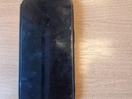 Melns telefons iPhone melnā silikona vāciņā.