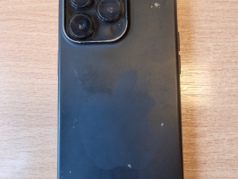 Melns telefons iPhone melnā silikona vāciņā.