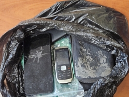 Maiss ar dažādām mantām un diviem mobilajiem telefoniem.