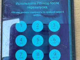 Melns mobilais telefons ar redzamiem ekrāna bojājumiem un PIN koda ievades ekrānu uz displeja