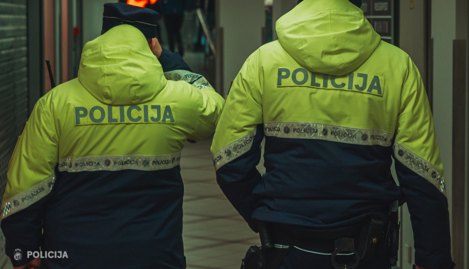 Divi policisti formas tērpos ar mugurām pret skatītāju