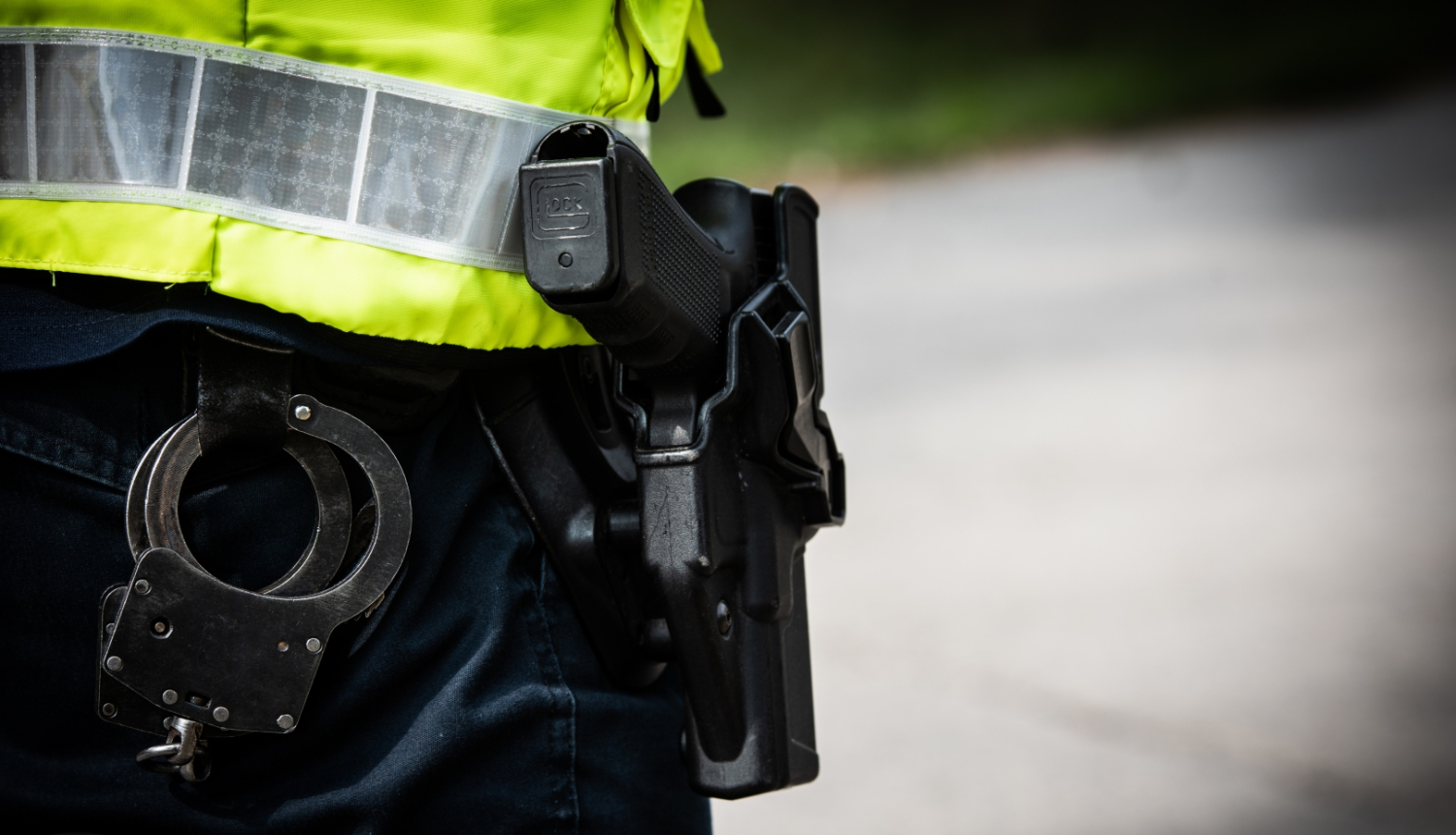 Policists no mugurpuses, pie jostas pielikti rokudzelži un ierocis