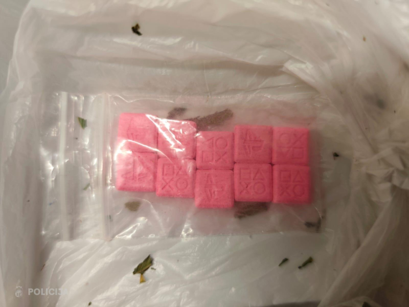 Neliels caurspīdīgs plastmasas maisiņš ar vairākām rozā kvadrātveida tabletēm