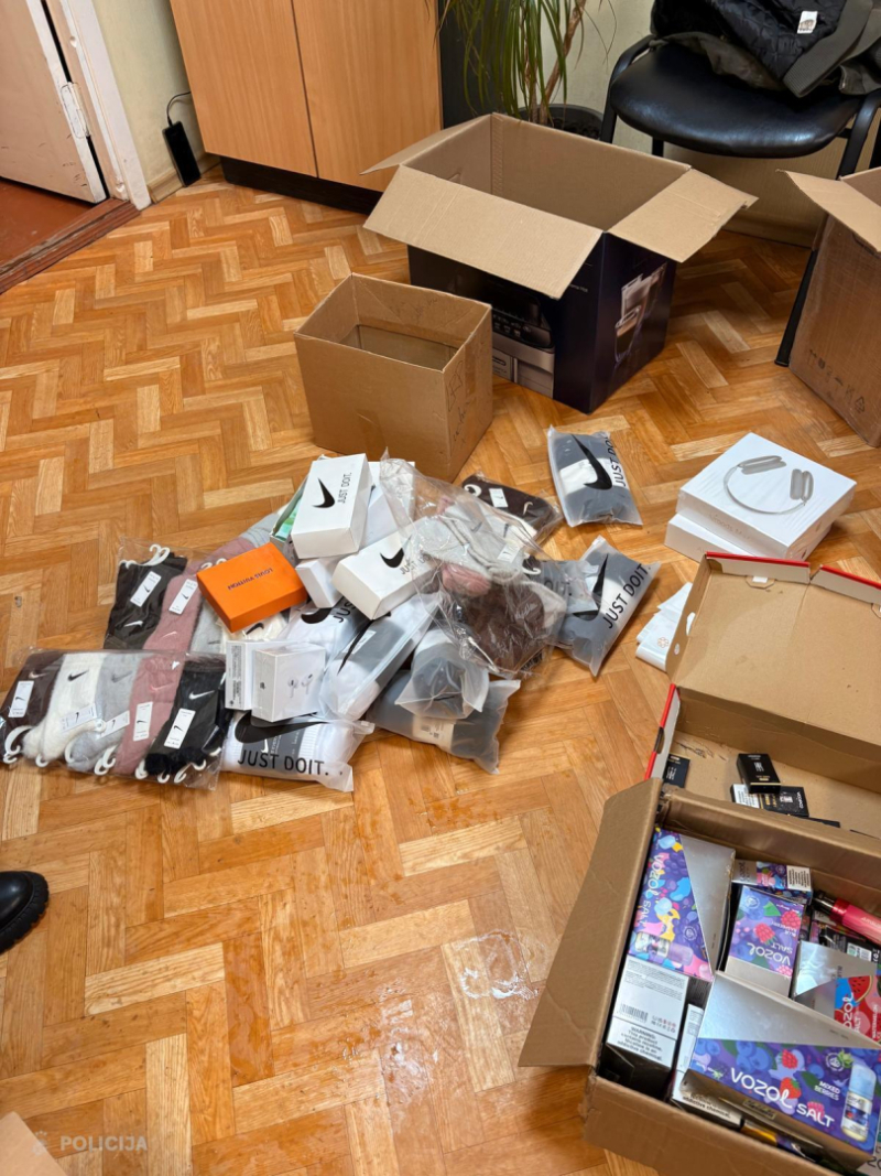 Uz grīdas izlikts apģērbs un elektronisko cigarešu iepakojumi, kas izņemti no kartona kastēm