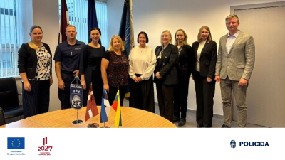 Valsts policijas pārstāvji un sadarbības partneri kopīgā grupas foto stāv sanāksmju telpā 