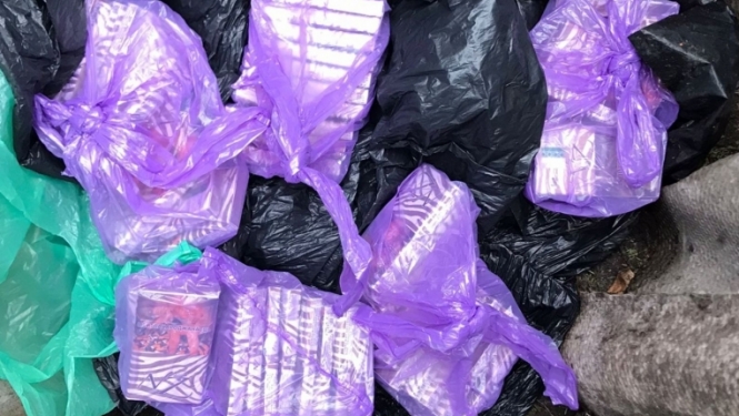 uz zemes redzami lillā plastmasas maisos iepakoti nelegālo cigarešu bloki