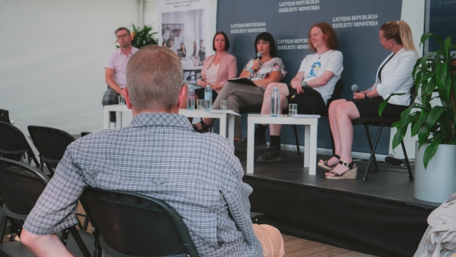 Sarunu festivāla apmeklētājs klausās diskusiju