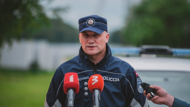 Policijas darbinieks runā mikrofonu priekšā