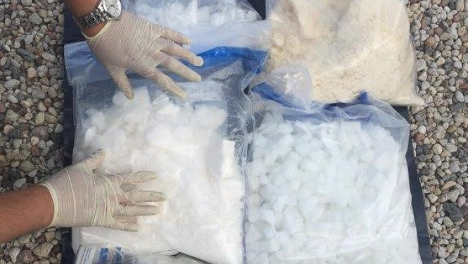 Narkotikas, sapakotas plastmasas maisiņos, novietas uz grīdas