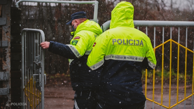 Policisti iet iekšā pagalmā pa atvērtiem vārtiem