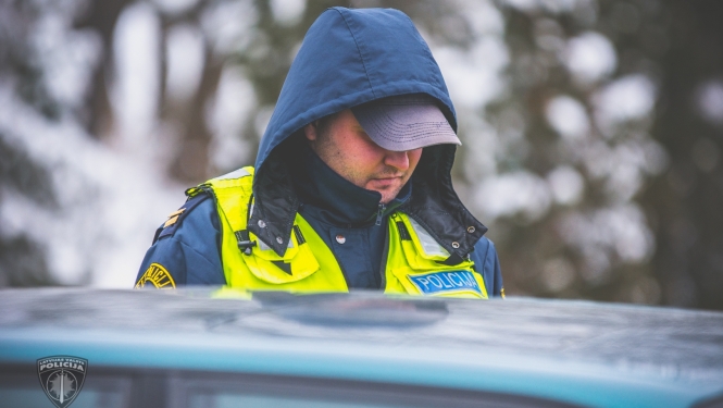 Ceļu policists pie automašīnas