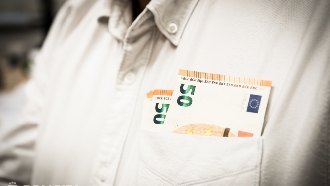 Ciilvēkam mugurā balts krekls un priekšējā krekla kabatā redzama daļa no 50 eiro banknotēm