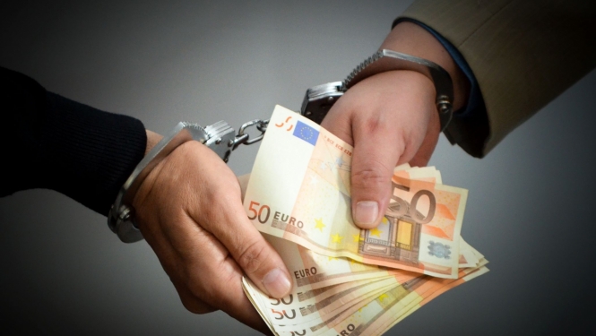 Ar rokudzelžiem sasaistītas divas rokas, kas tur daudz 50 eiro banknotes