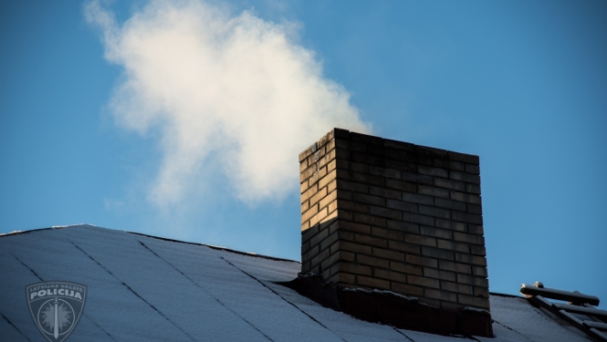 Apsnidzis mājas jumts, no skursteņa kūp dūmi