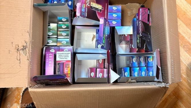 Kartona kaste ar elektroniskajām cigaretēm, kas novietota uz grīdas