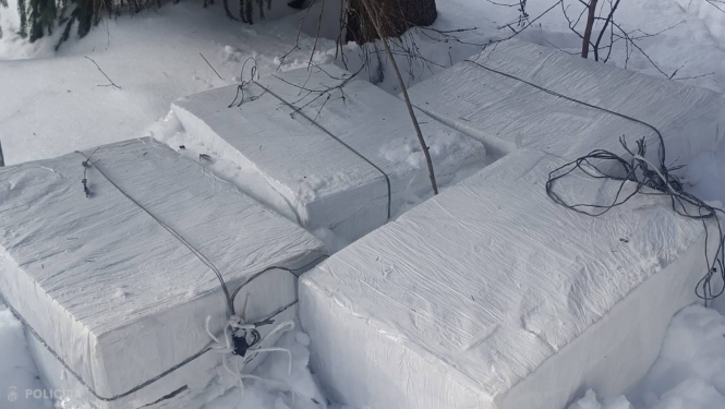 četri iepakojumi ar cigaretēm sniegā