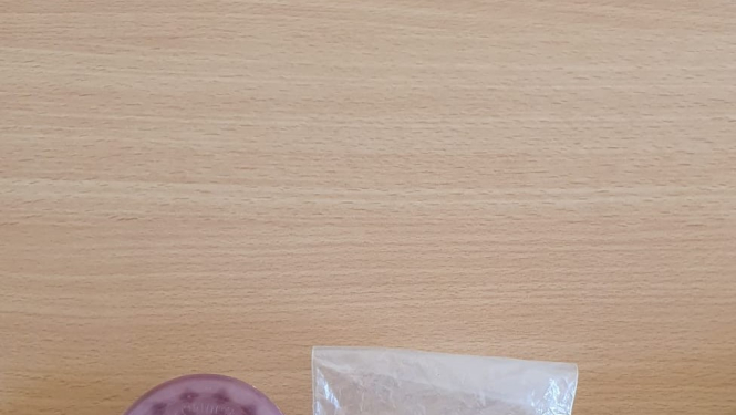 Caurspīdīgs maisiņš, kurā redzamas četras savirpinātas folija bumbiņas un rozā apaļš trauciņš blakus