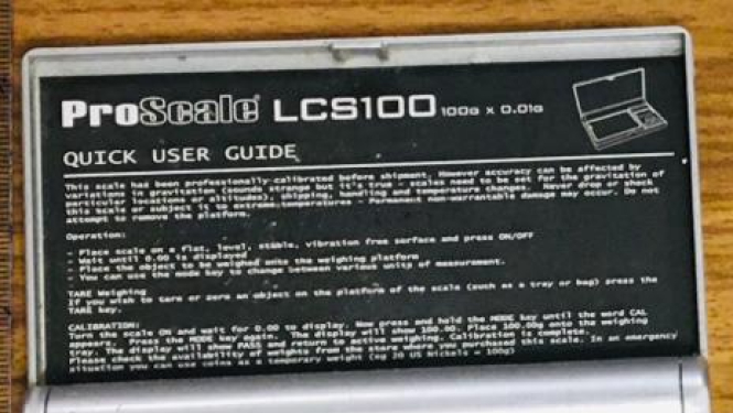 Elektroniskie svariņi un divas paciņas ar baltu pulverveida vielu iekšā