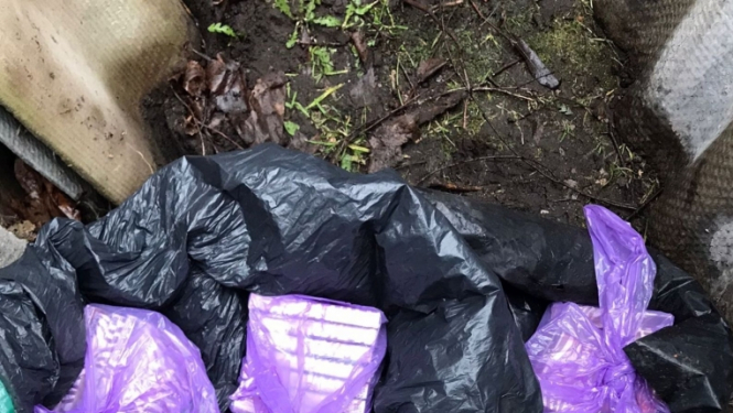 uz zemes redzami lillā plastmasas maisos iepakoti nelegālo cigarešu bloki