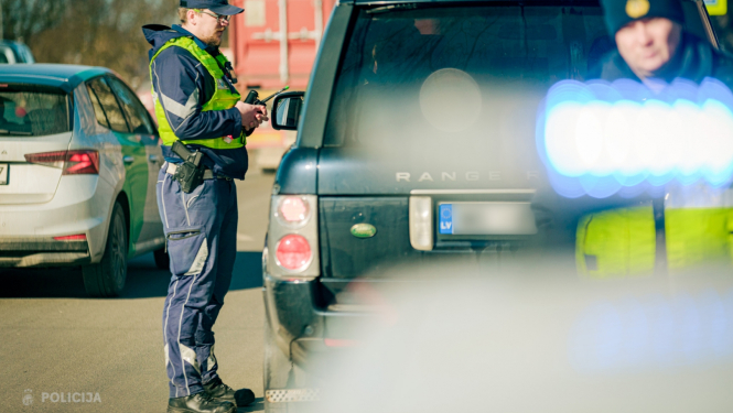 Valsts policijas darbinieki pie automašīnas