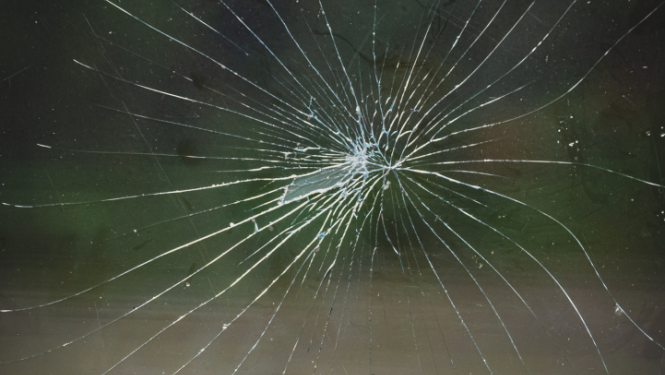 tuvplāns ar stipri saplaisājušu stiklu pēc trieciena, plaisas radiāli izplešas no viena centrālā trieciena punkta