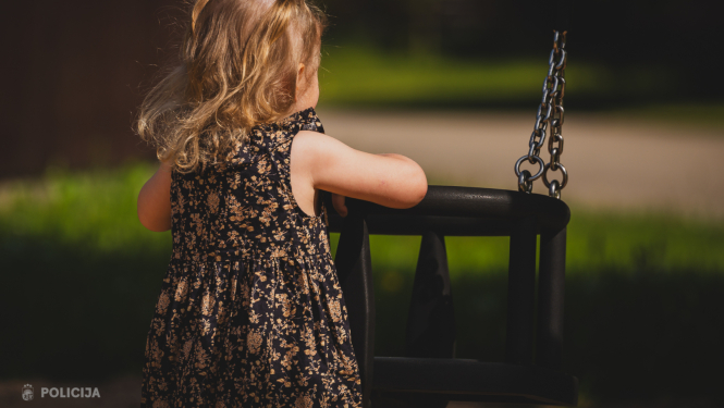 maza meitenīte rotaļulaukumā pie šūpolēm