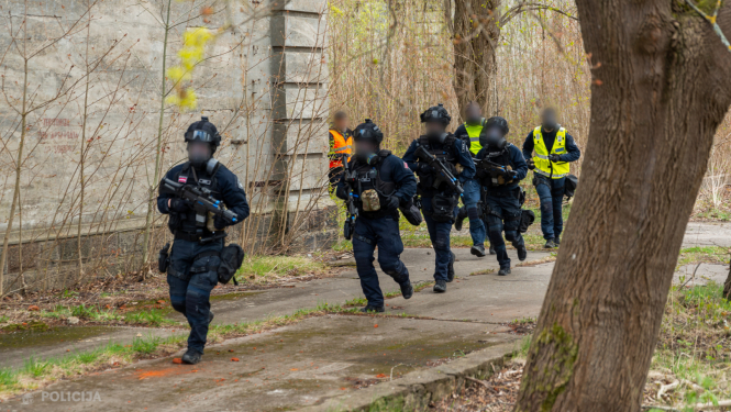 policistis ekipējumā skiren gar ēku