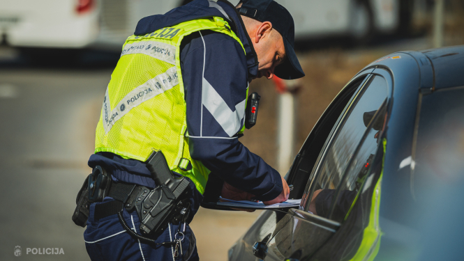 policists pieliecies pie transportlīdzekļa, kuru apturējis par kādu pārkāpumu