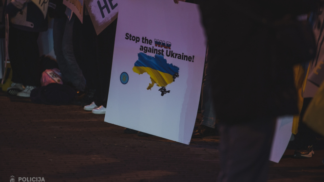 Plakāts ar uzrakstu "Stop war against Ukraine" tulkojumā - apturiet karu pret Ukrainu