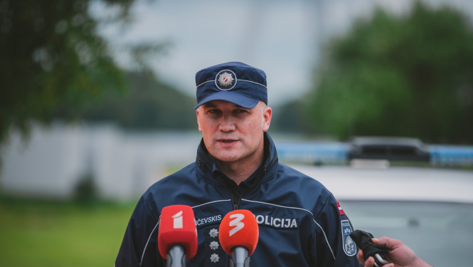 Policijas darbinieks runā mikrofonu priekšā
