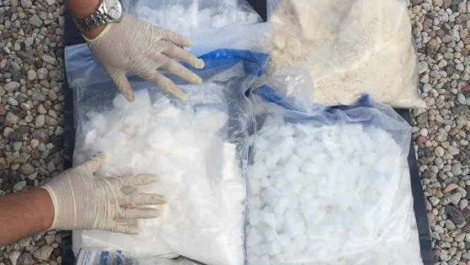 Narkotikas, sapakotas plastmasas maisiņos, novietas uz grīdas