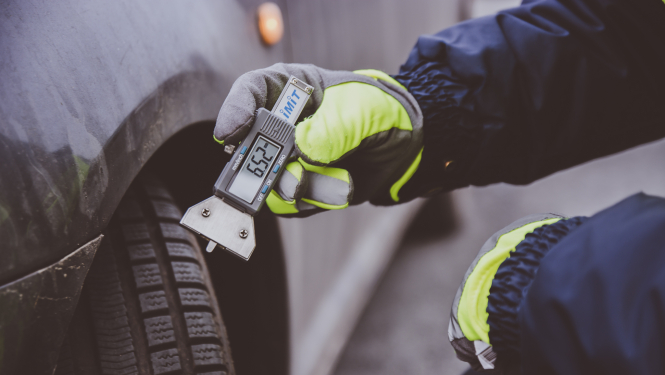 Automašīnas riepa, kurai ar mērierīci tiek mērīts protektoru dziļums