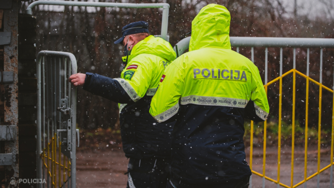 Policisti iet iekšā pagalmā pa atvērtiem vārtiem