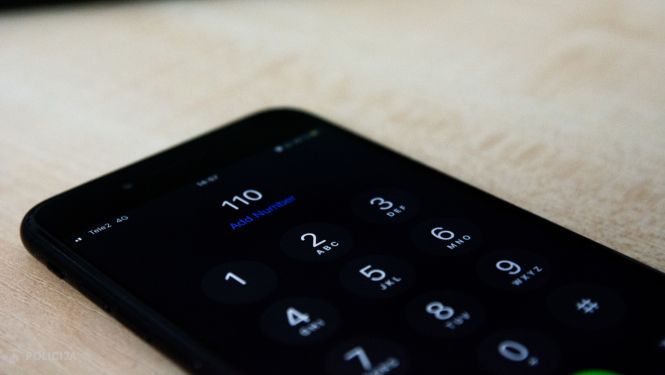 Viedierīce, kuras ekrānā attēlots telefona numurs 110