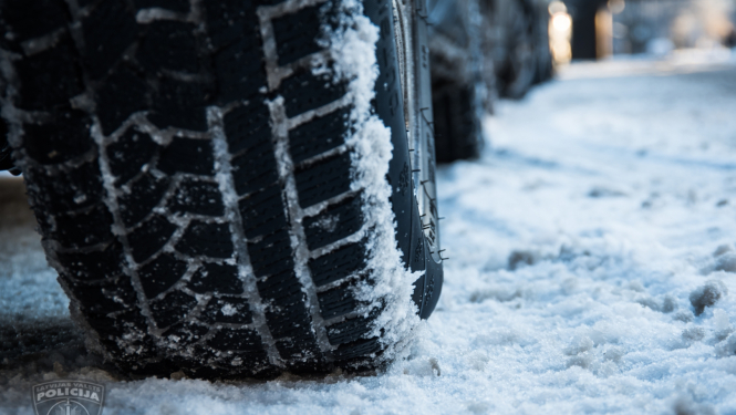 Automašīnas riepa tuvplānā uz sniegota ceļa