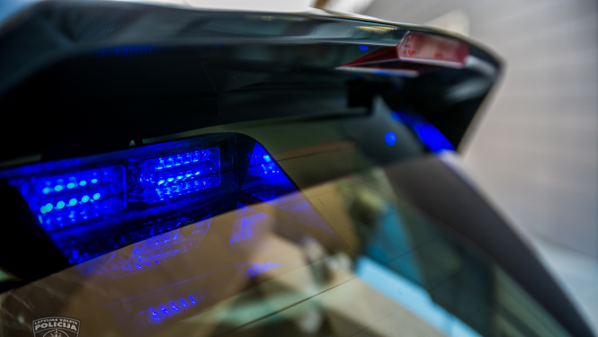 No ārpuses tuvplānā nofotografēta policijas automašīna, lai redzamas zilās gaismas