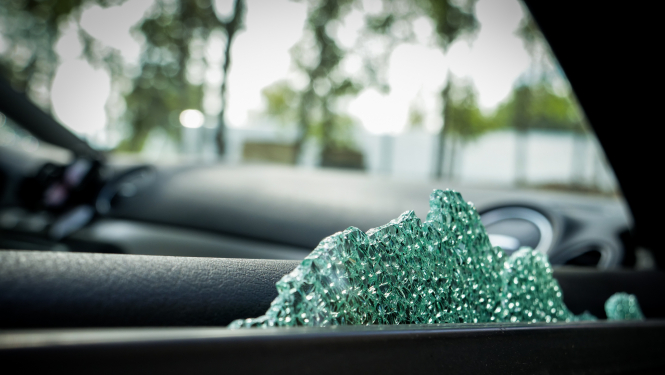 Automašīnas sānu durvis tuvplānā, redzams izsists loga stikls