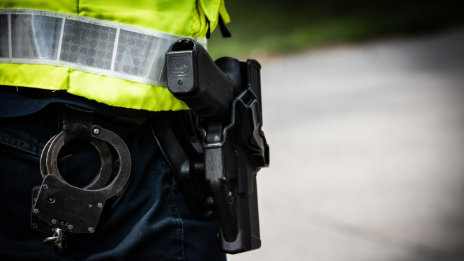 Policists no mugurpuses, pie jostas pielikti rokudzelži un ierocis