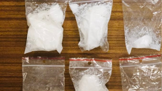 Seši caurspīdīgas plastmasas maisiņi, kuros ir baltas krāsas pulverveida viela un vienā vairākas baltas krāsas tabletes