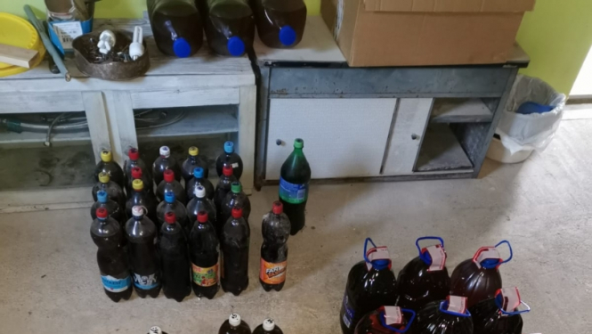 Uz grīdas dažāda tilpuma pudeles