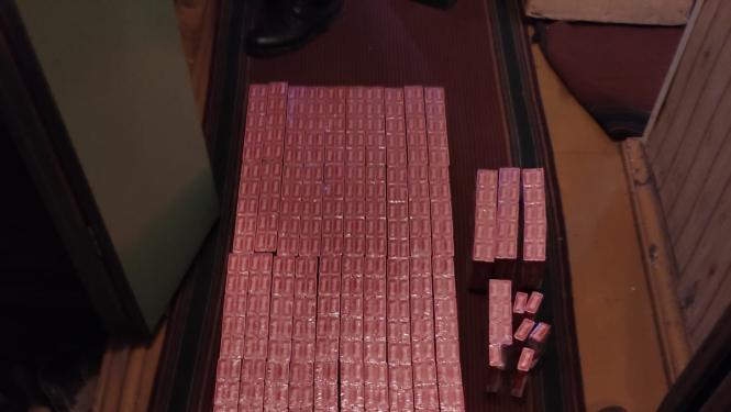 Uz grīdas saliktas sarkanas cigarešu paciņas