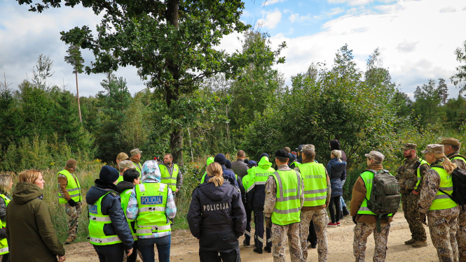 Policisti un zemessargi sapulcējušies pie meža, pirms došanās iekšā meklēt bezvēsts pazudušu ogotāju