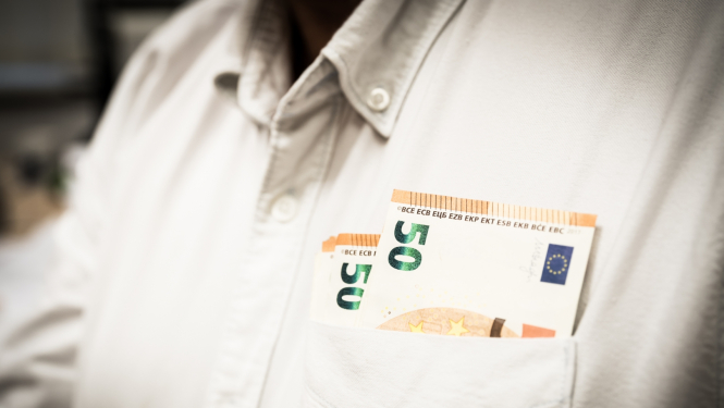 Ciilvēkam mugurā balts krekls un priekšējā krekla kabatā redzama daļa no 50 eiro banknotēm