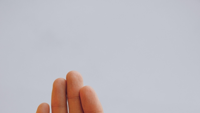 Maza bērna plauksta ielikta pieauguša cilvēka plaukstā